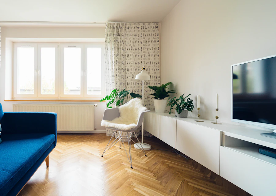 A bright room with a blue sofa and herringbone floor